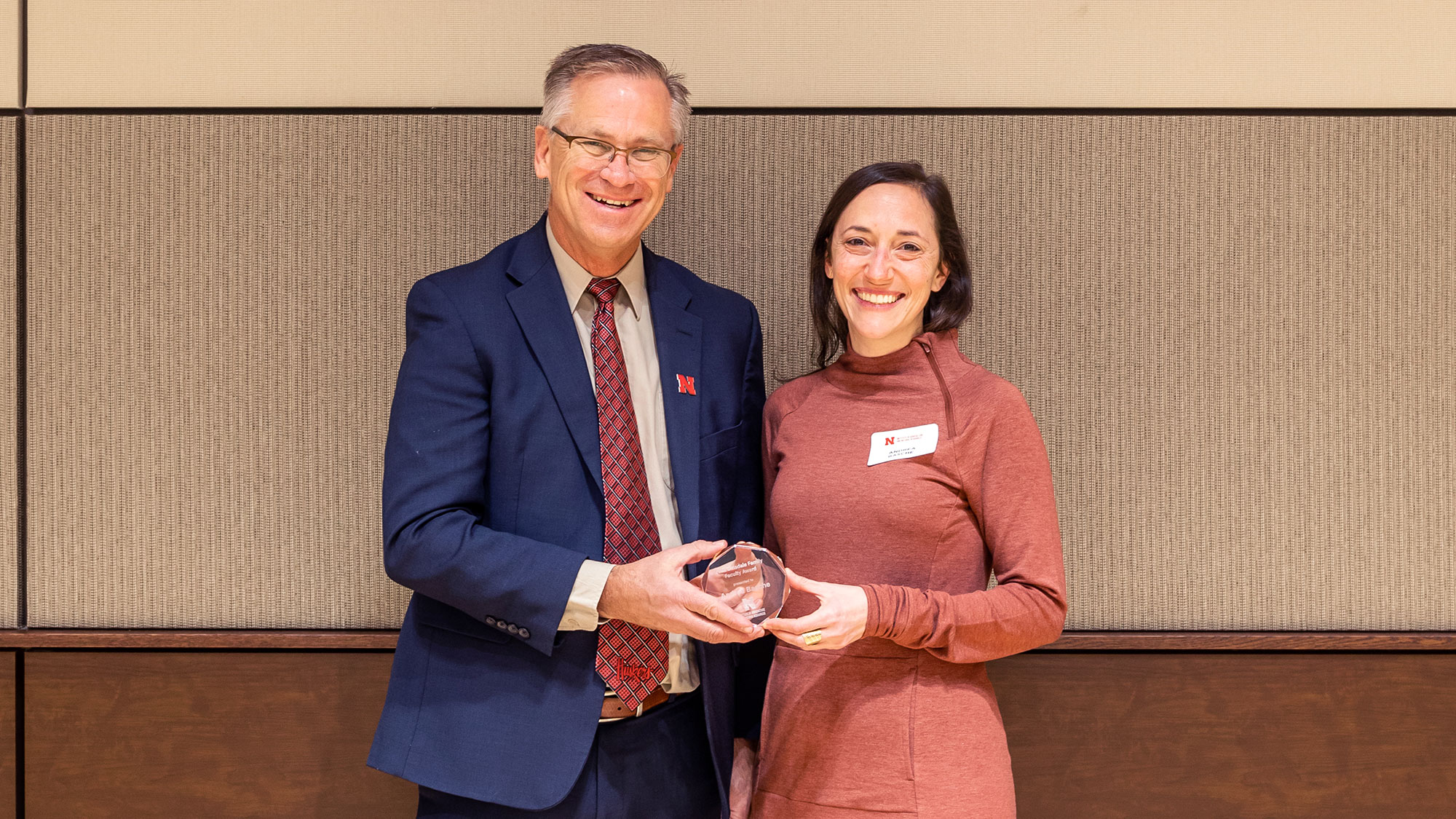 Rich Bischoff, associate vice chancellor of IANR (left), presents Andrea Basche with the Dinsdale Family Faculty Award at the Distinguished Fellowships and Awards Luncheon Dec. 7. Loren Rye | Pixel Lab