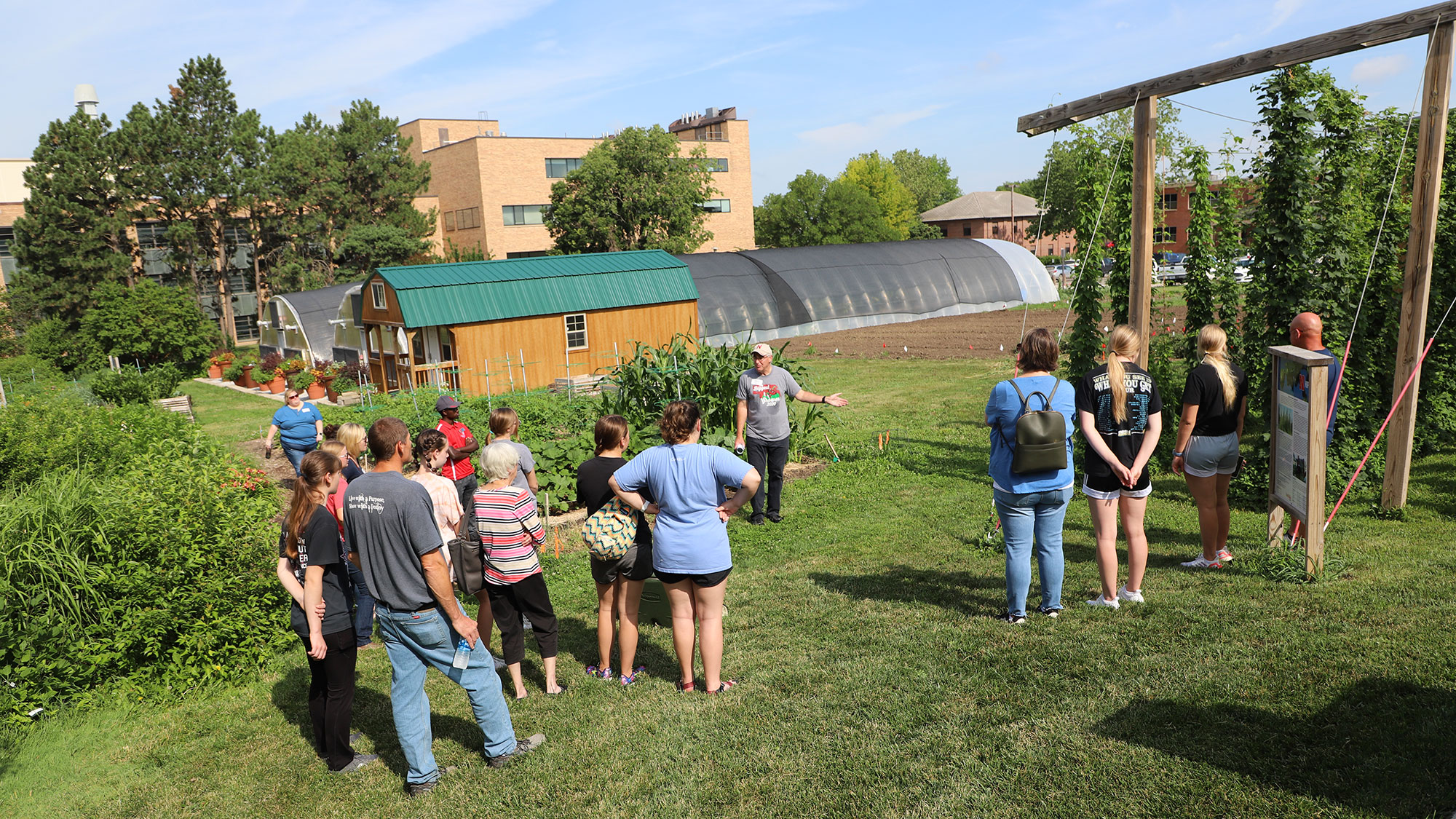 Nebraska high school students and their families listen to Stacy Adams, The Biggest Grower program coordinator, speak about speciality crop production near the East Campus Hops Planting Garden on June 30.