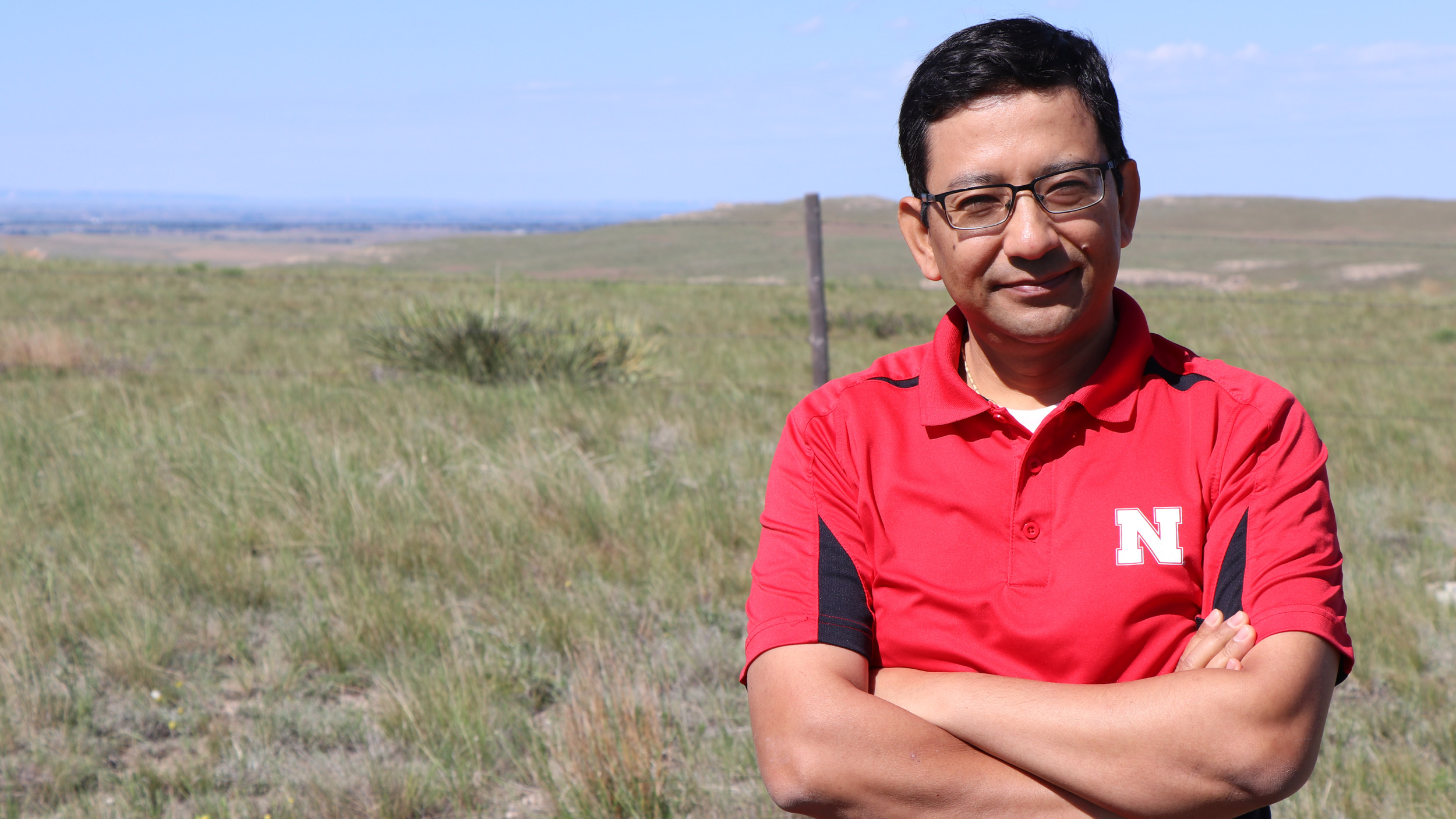 Bijesh Maharjan stands in front of a pasture north of Scottsbluff consisting of native soil and plant communities. His concept would define Soil Health Gap as the difference between soil health in an undisturbed native virgin soil and soil health in a given agroecosystem, such as a tilled field. David Ostdiek  | Communications Specialist Panhandle REC
