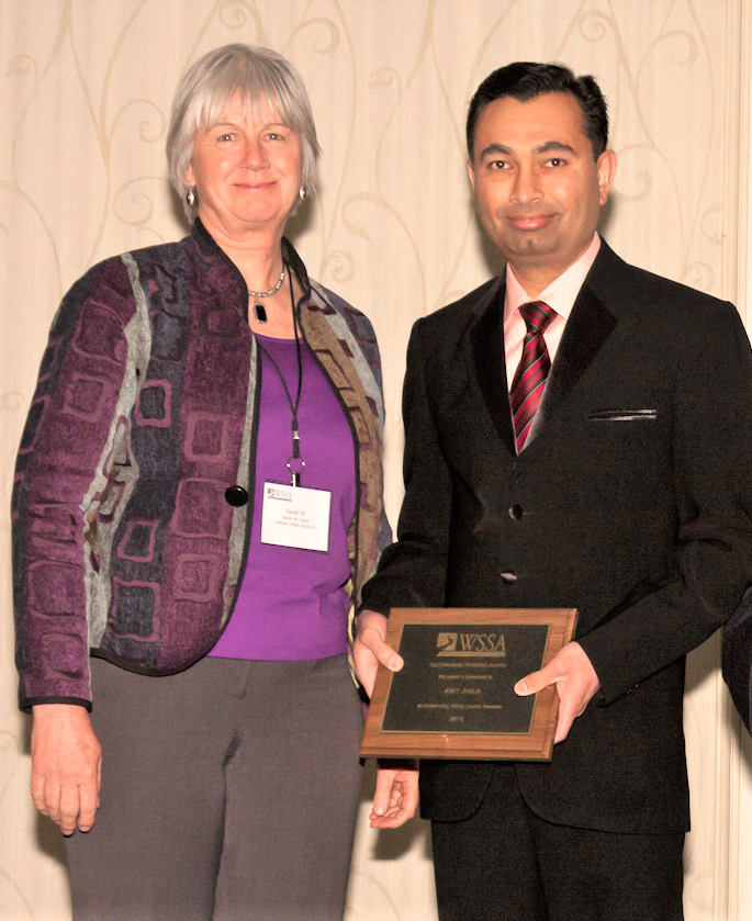 Amit Jhala, right, receives the Outstanding Reviewer Award at the 58th Annual Conference of the Weed Science Society of America. Pictured with Jhala is Sara Ward, director of publication, Weed Science Society of America.