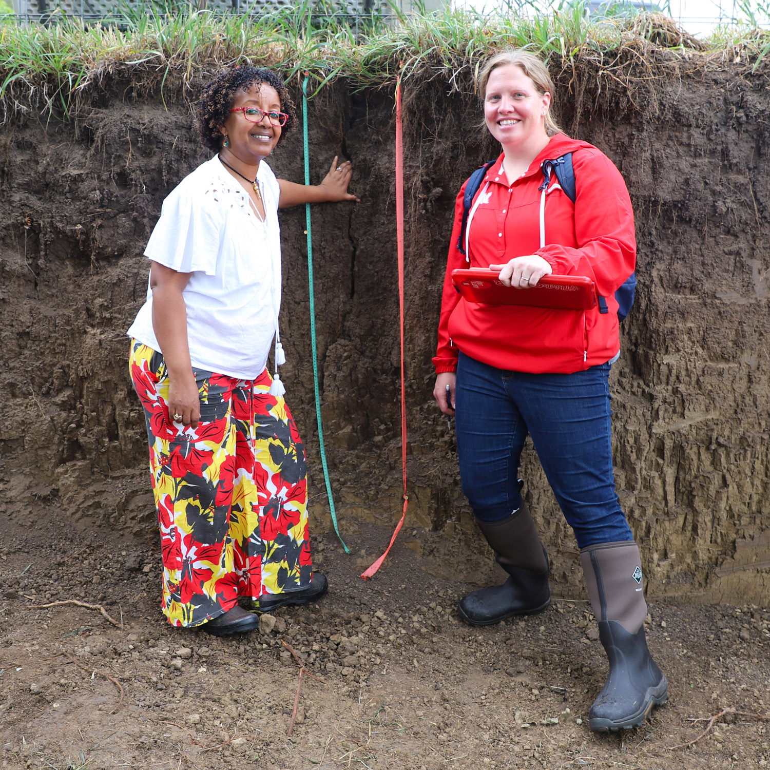 Agronomy and Horticulture department head Martha Mamo (left) and Becky Young, Agronomy and Horticulture assistant professor of practice and soil judging coach, pose in the East Campus soil pit during PLAS/SOIL 279 Soil Evaluation class.