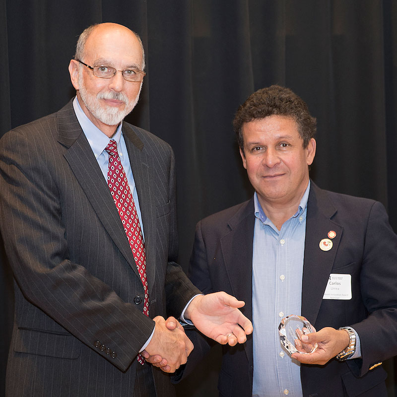 Interim IANR Vice Chancellor Ron Yoder presents an Omtvedt Innovation Award to Carlos Urrea 