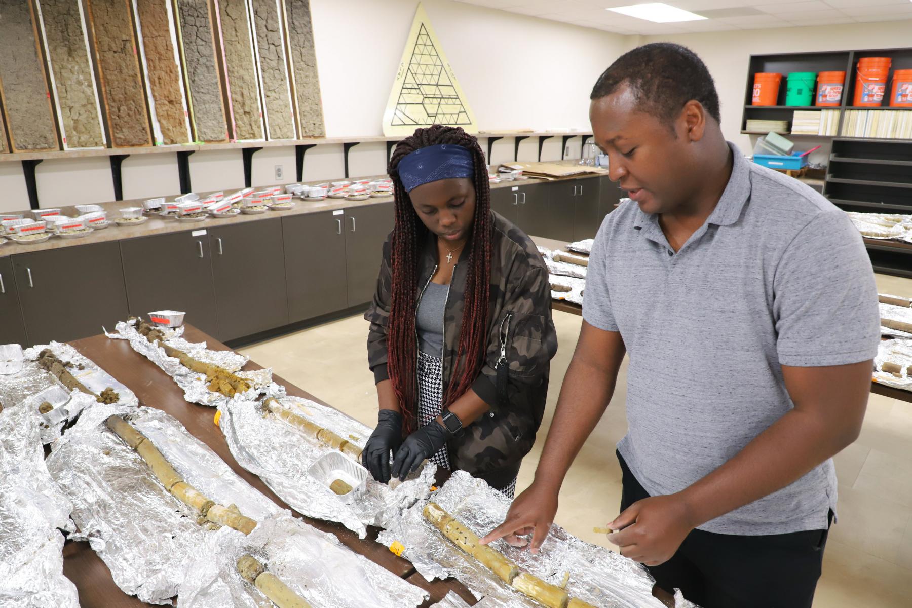 Andromede “Andy” Uwase, left, senior integrated science major, and Christopher Anuo, agronomy doctoral student, evaluate soil cores 
