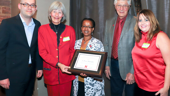 Martha Mamo, center, and Raymond Ward, second from right, present award to A. Bruce Maunder's family. 