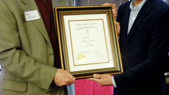 Chuck Hibberd presenting The Honor Society of Agriculture Gamma Sigma Delta Extension Award of Merit to Amit Jhala.