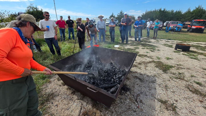 Kim Slezak, Nebraska Forest Service, tends to the Oregon Kiln at the biochar field day Sept. 22.