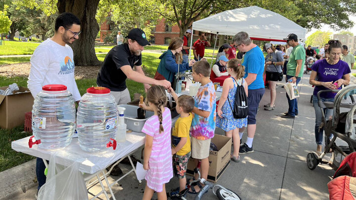 Mahmoud Sleem, research assistant intern (from left), Assistant Professor Michael Kaiser, and doctoral student Britt Fossum help community members mix biochar-amended potting soil for seed starters July 8 at the East Campus Discovery Days and Farmers Market. 