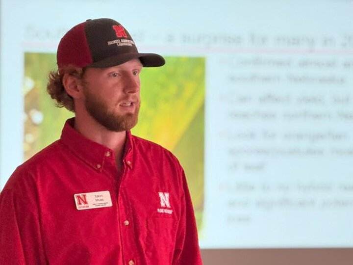 A candid photo of Talon Mues giving a presentation as an extension education