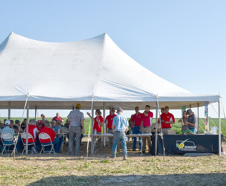 Nebraska Extension faculty gather under the main tent to welcome attendees at one of the 2024 Soybean Management Field Days.