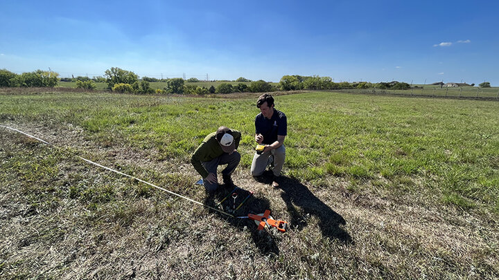 Uden (on right) and a student, Trace Stauble, mark a location at the university’s Nine-Mile Prairie with a high-accuracy GPS unit.