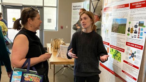 Britt Fossum, an agronomy graduate student, speaks with the public about biochar application combined with no-till and cover crops at the Lincoln Earth Day event April 23.