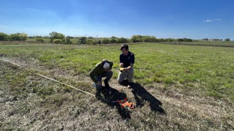 Dan Uden, on right, helps Trace Stauble, a graduate student in agronomy, use GPS technology to collect grassland data.