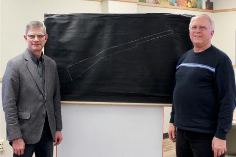 Thomas and Birdie Goodding’s grandsons, Gary Goodding (left) and Rich Goodding (right), pose in the newly remodeled Goodding Learning Center with the drawing Dr. Goodding used to announce class quizzes.