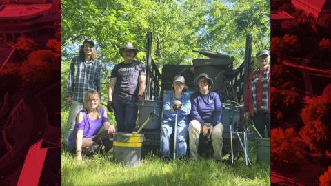 Courtesy Jennifer Weisbrod (crouched, second from left), John Hay (third from left), and volunteers stand in front of the truck that was used to assist the removal of trash in the creek.